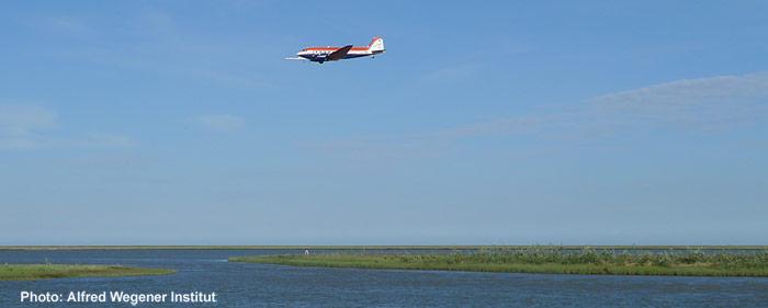 Das Forschungsflugzeug des AWI Polar 5 beim Messflug in der Nähe eines Camps des Geological Survey of Canada.